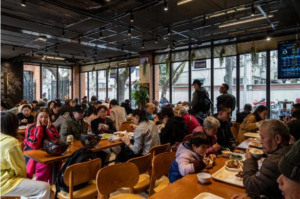 吃饭的时候,桌边坐着年轻和年老的用餐者 吃饭的时候,桌边坐着年轻和年老的用餐者