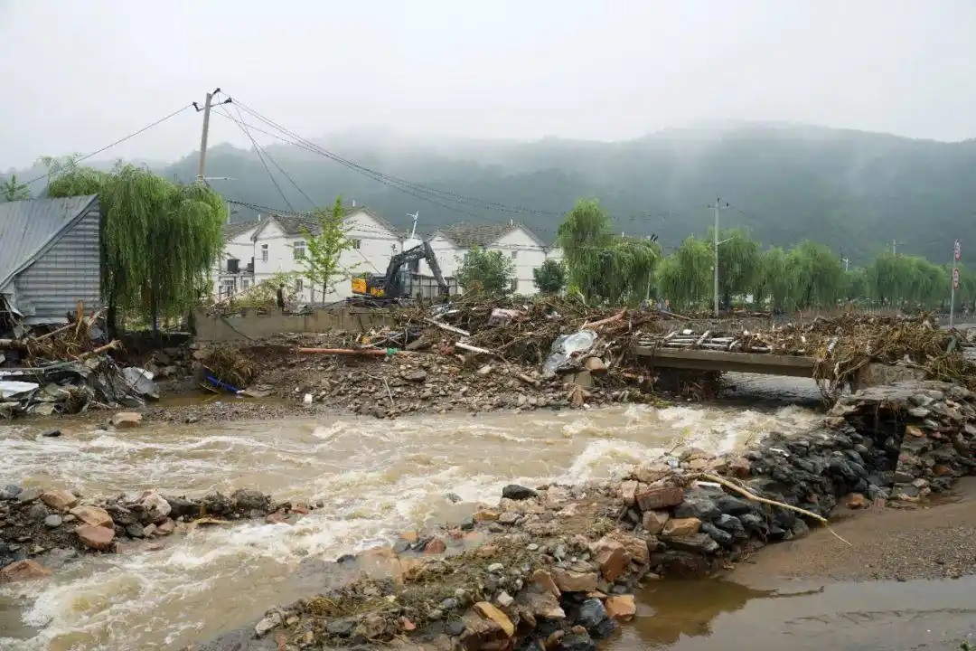 在北京市密云区石城镇西湾子村，施工救援人员在清理被杂物阻断的桥梁