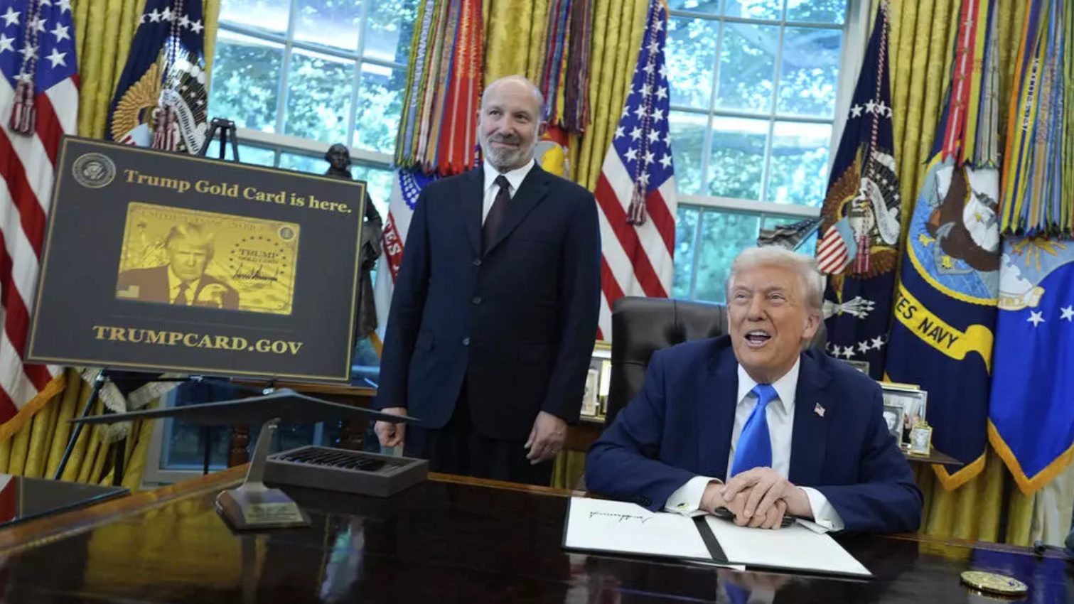 9月19日，美国总统特朗普在白宫椭圆形办公室发表讲话，商务部长卢特尼克在“特朗普金卡”海报旁聆听 ...